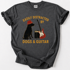 A dark gray heather t-shirt with a graphic print of a black dog wearing a red hat, a red electric guitar, and a speaker, with the text 'EASILY DISTRACTED BY DOGS & GUITAR' in yellow. The shirt is laid flat on a light gray background.