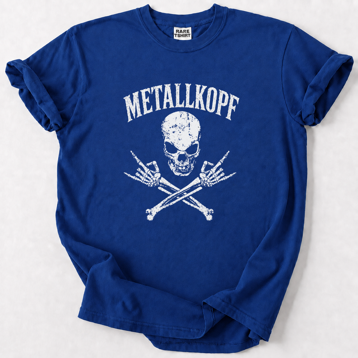 A royal blue short-sleeve t-shirt with a distressed white graphic on the front featuring the text 'METALLKOPF' above a skull and crossed bones design. The inner neck label shows the brand 'RARE FINDS'.