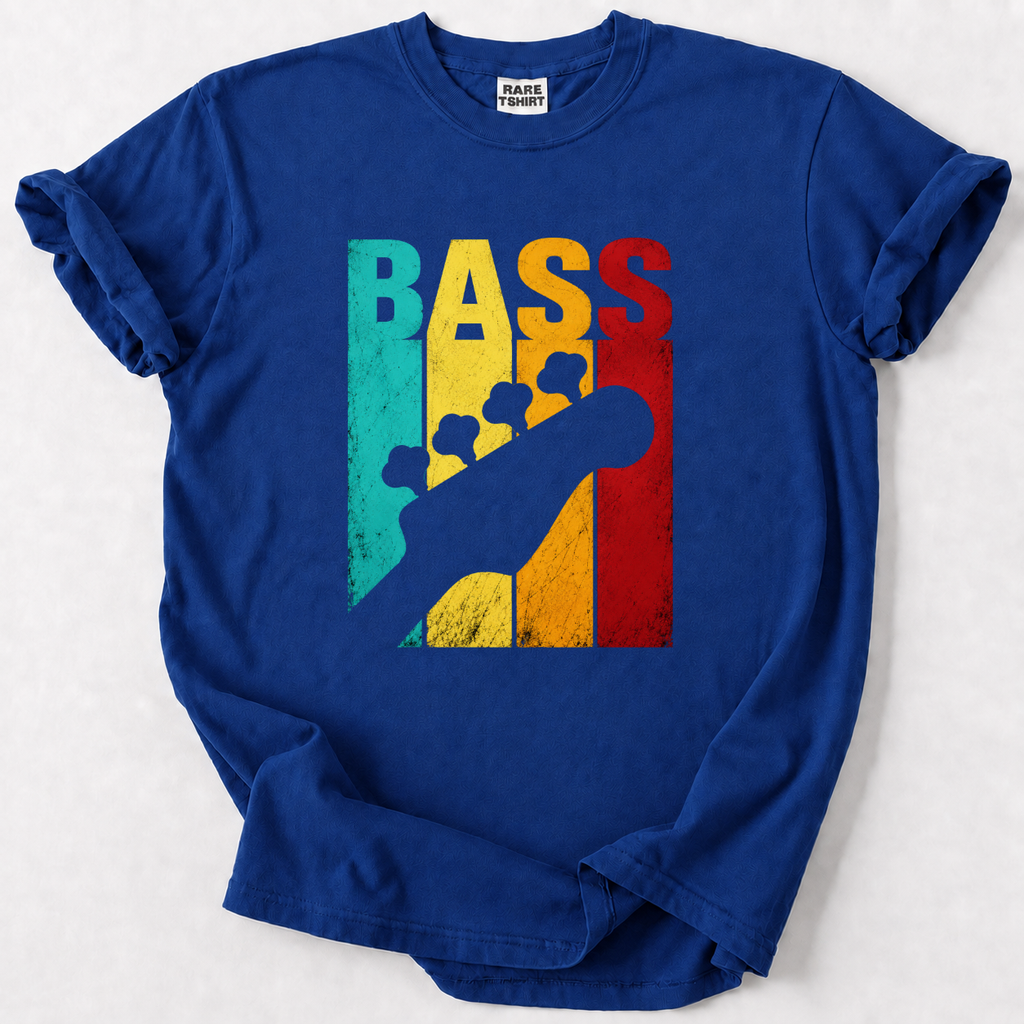 A royal blue short-sleeve t-shirt with a graphic print on the front. The graphic features the word 'BASS' in large, distressed vertical letters colored teal, yellow, and red, overlaid with a dark blue silhouette of a bass guitar.