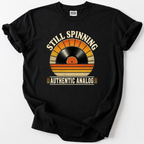 Retro vinyl record t-shirt with "Still Spinning, Authentic Analog" design, black tee