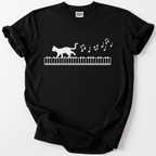Whimsical cat-on-piano graphic tee for music lovers. Soft, premium cotton comfort meets rare artistic design. The perfect gift for pianists &amp; cat lovers.